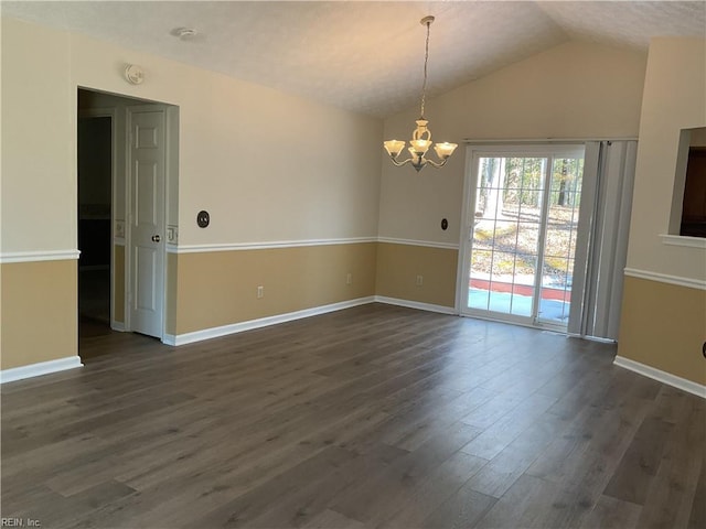 unfurnished room featuring a chandelier, vaulted ceiling, and dark hardwood / wood-style floors