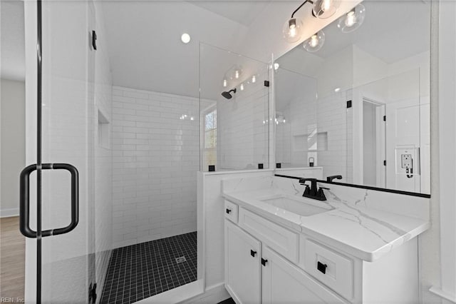 bathroom with vanity and a shower with door