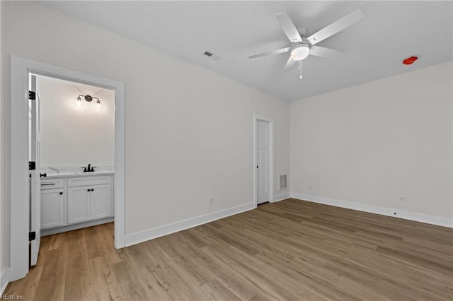 empty room with ceiling fan, sink, and light hardwood / wood-style floors