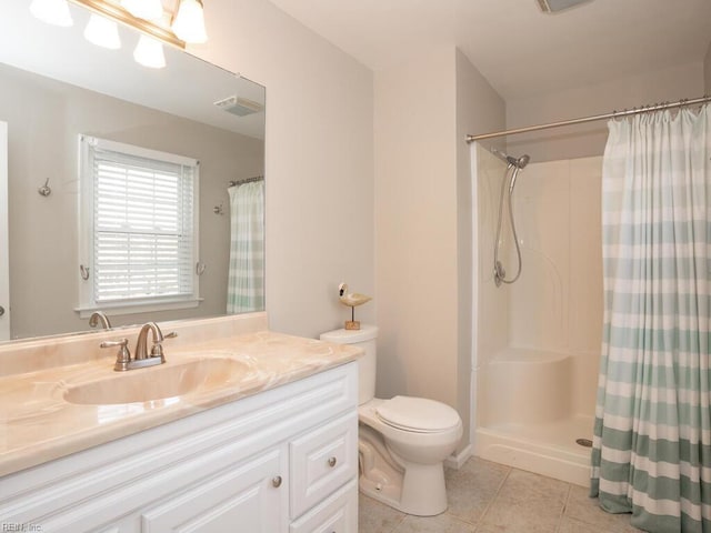 bathroom with tile patterned flooring, vanity, toilet, and walk in shower