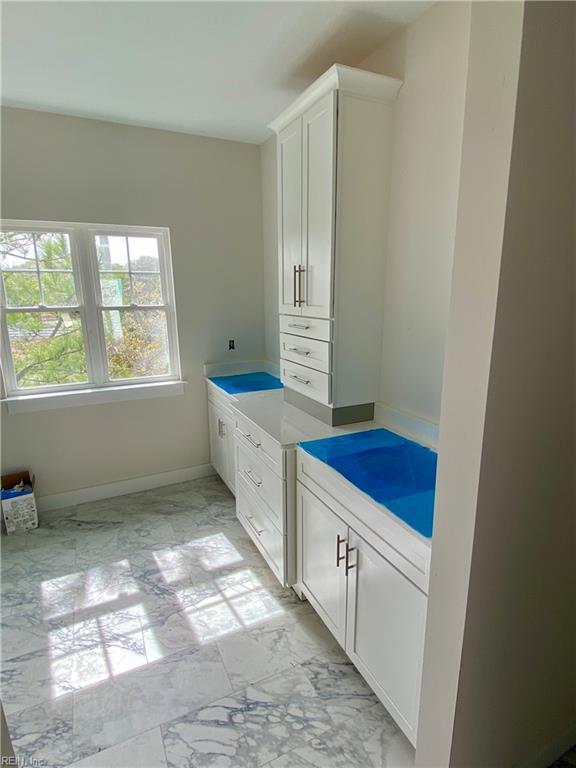 bathroom featuring marble finish floor and baseboards