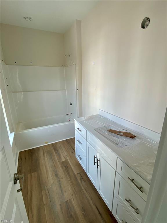 full bath featuring shower / tub combination, wood finished floors, and vanity