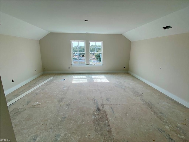 bonus room with vaulted ceiling and baseboards