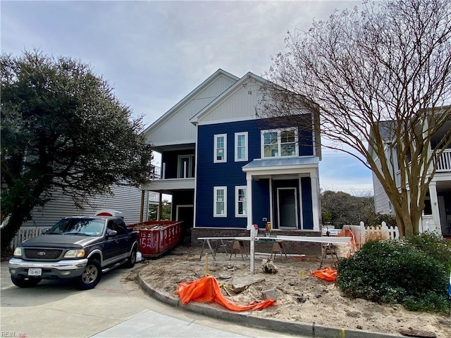 view of front of house with concrete driveway and a balcony