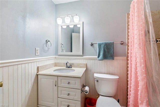 bathroom with toilet, vanity, and curtained shower