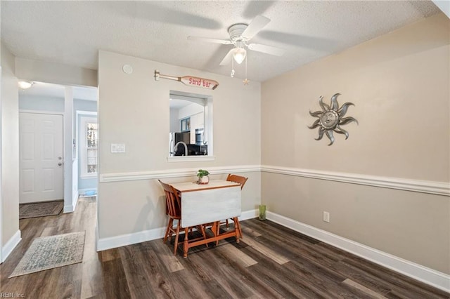 dining room featuring ceiling fan, dark hardwood / wood-style flooring, and a textured ceiling