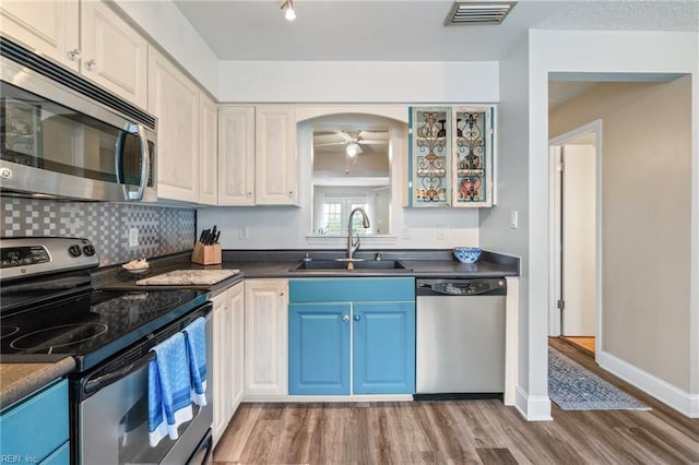 kitchen featuring ceiling fan, sink, hardwood / wood-style floors, and appliances with stainless steel finishes