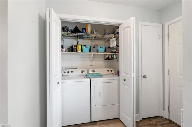 laundry room featuring washing machine and dryer and wood-type flooring