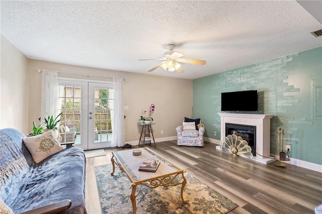 living room featuring a textured ceiling, ceiling fan, wood-type flooring, and french doors