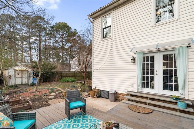 wooden deck with a shed and french doors