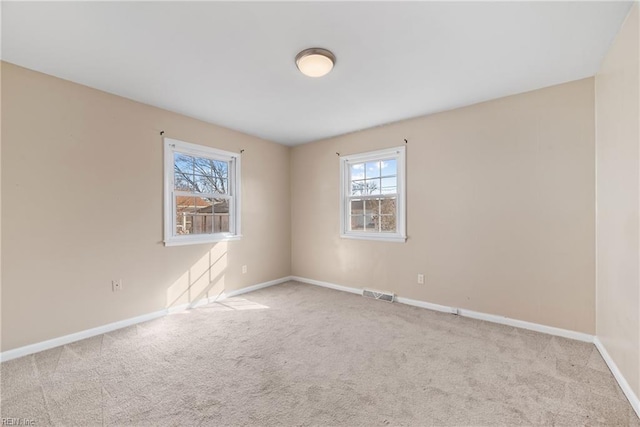 spare room featuring light carpet