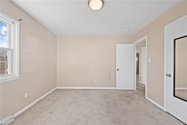 unfurnished room featuring light colored carpet