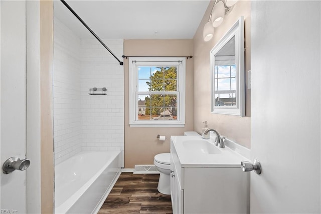 full bathroom featuring tiled shower / bath, toilet, vanity, and wood-type flooring