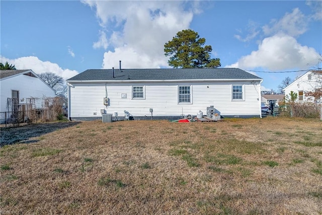 rear view of property featuring a yard and central air condition unit