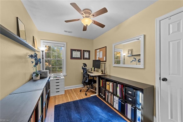 home office with wood-type flooring and ceiling fan