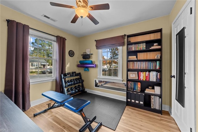 workout room featuring light wood-type flooring and ceiling fan