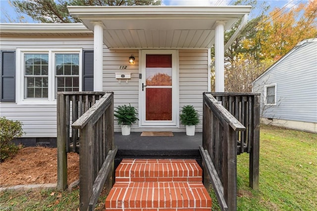 view of exterior entry with a lawn