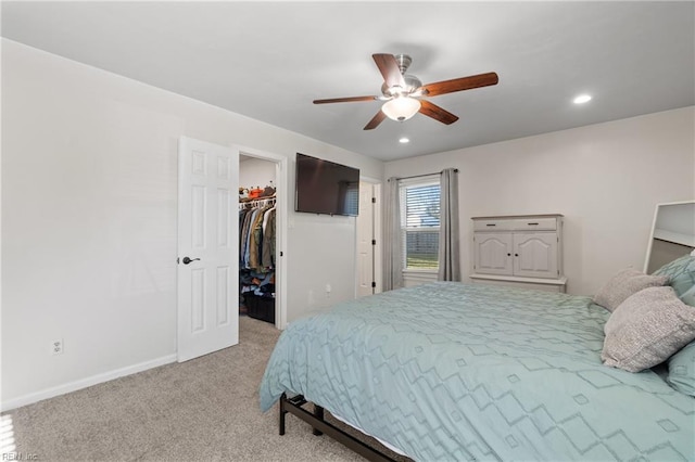 carpeted bedroom featuring ceiling fan, a spacious closet, and a closet