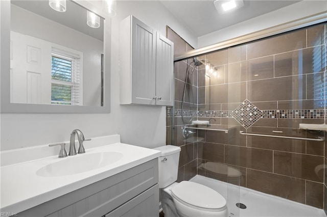 bathroom featuring toilet, walk in shower, and vanity