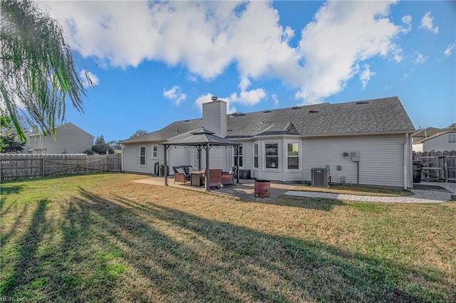 rear view of property featuring a lawn, central AC, a patio, and a gazebo