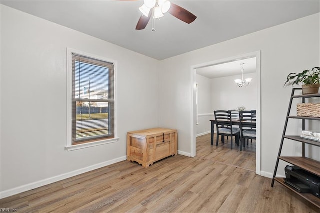 interior space featuring ceiling fan with notable chandelier and hardwood / wood-style floors