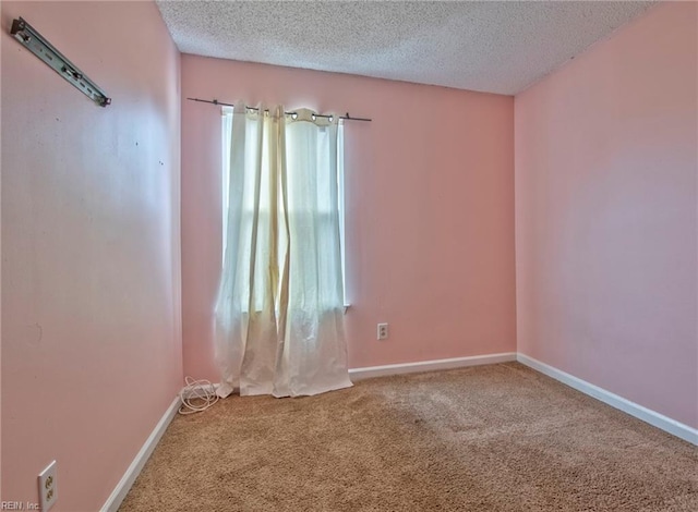 spare room featuring a textured ceiling and carpet flooring