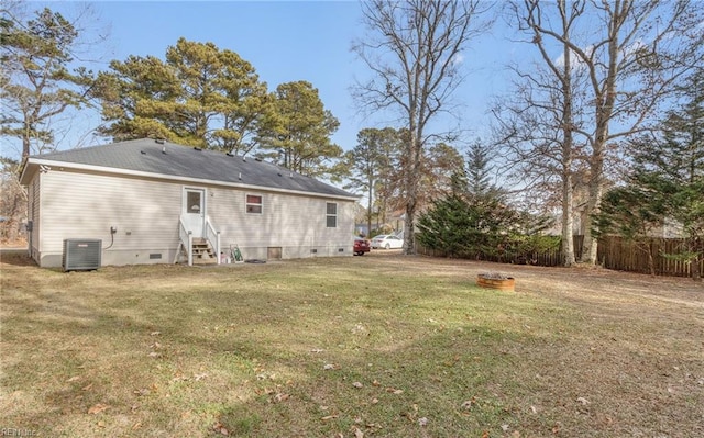 back of house with a lawn and central air condition unit