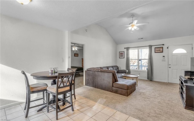 living room with a textured ceiling, light colored carpet, and vaulted ceiling