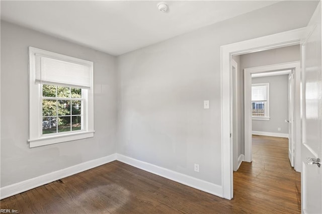 unfurnished room with dark wood-type flooring