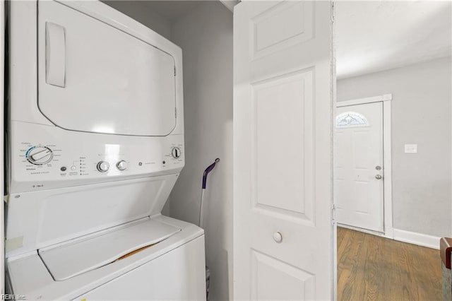 washroom with wood-type flooring and stacked washing maching and dryer