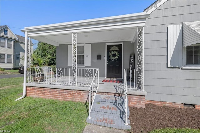 property entrance with a porch and a yard