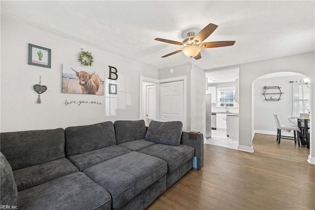 living room featuring ceiling fan, sink, and hardwood / wood-style flooring