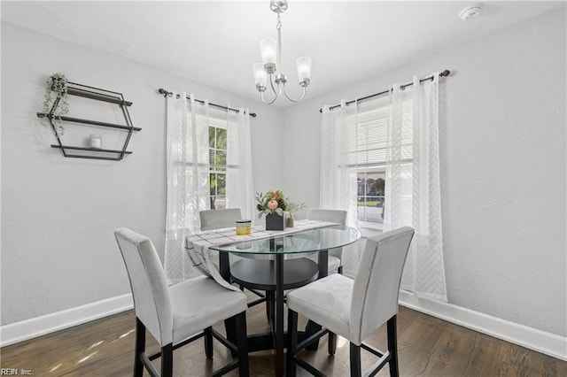 dining area featuring dark hardwood / wood-style floors and an inviting chandelier