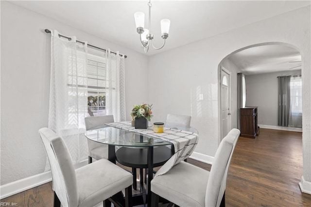 dining room with dark hardwood / wood-style flooring and a chandelier