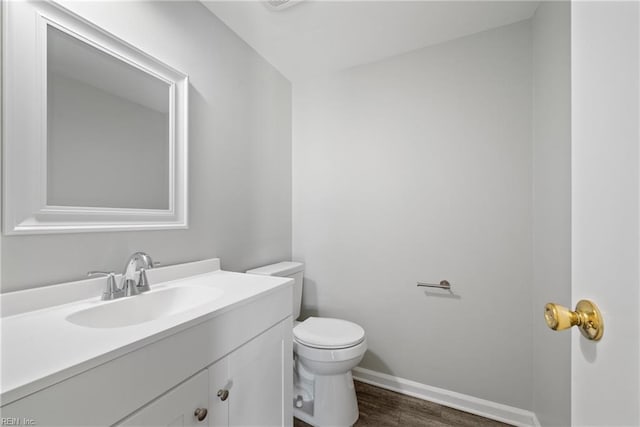 bathroom featuring toilet, hardwood / wood-style floors, and vanity