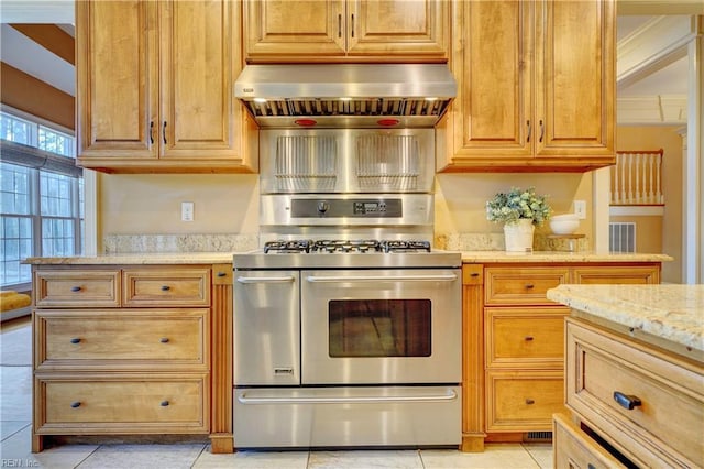 kitchen with light stone counters, ornamental molding, light tile patterned floors, extractor fan, and double oven range