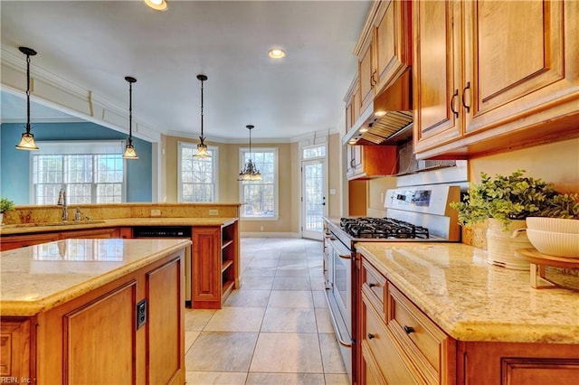 kitchen with appliances with stainless steel finishes, light stone countertops, a kitchen island, sink, and decorative light fixtures