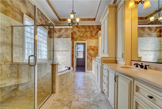 bathroom featuring a raised ceiling, a chandelier, and ornamental molding