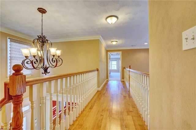 hall featuring ornamental molding, light wood-type flooring, and a chandelier