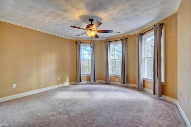 carpeted spare room featuring ceiling fan and ornamental molding