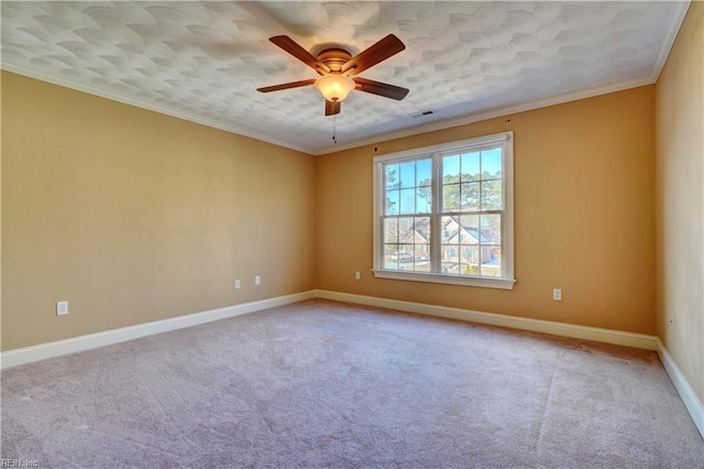 spare room featuring ceiling fan, crown molding, and light colored carpet