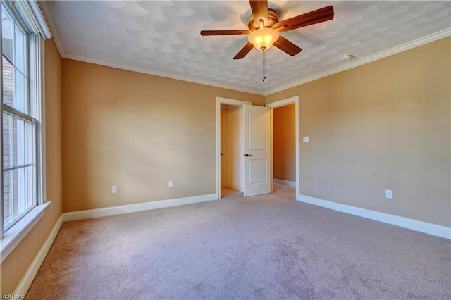 spare room featuring ornamental molding, light colored carpet, and a wealth of natural light