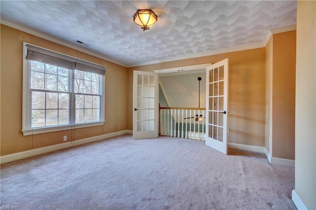 carpeted empty room featuring ornamental molding and french doors