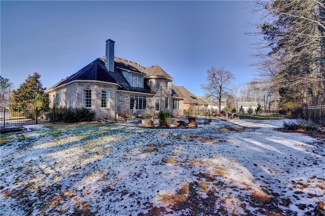 view of snow covered rear of property