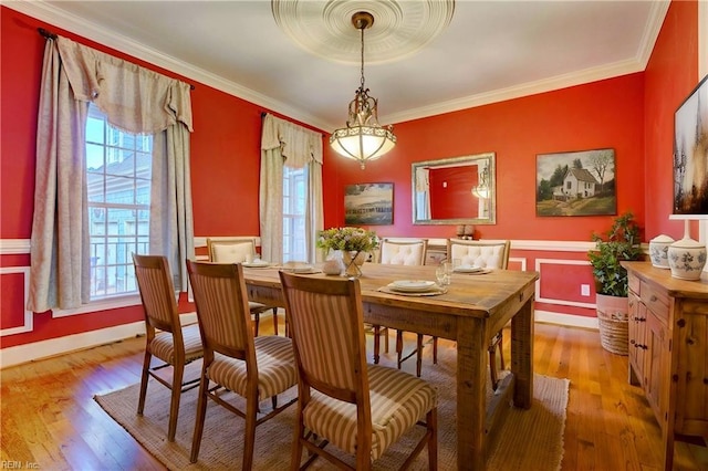 dining room featuring ornamental molding and light hardwood / wood-style flooring