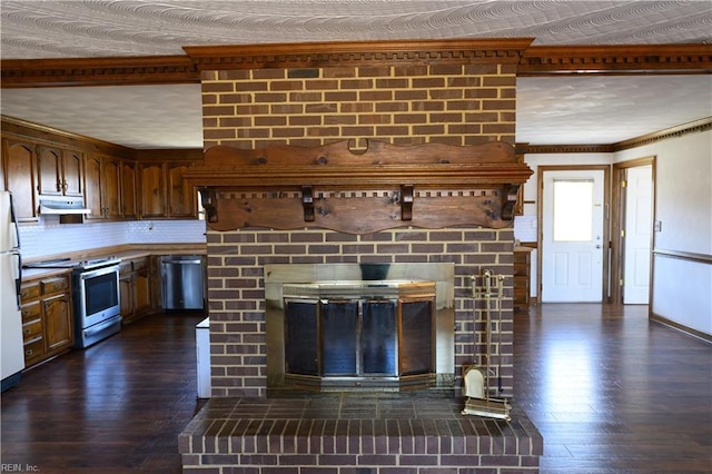 kitchen with a brick fireplace, dark wood-type flooring, stainless steel appliances, and tasteful backsplash