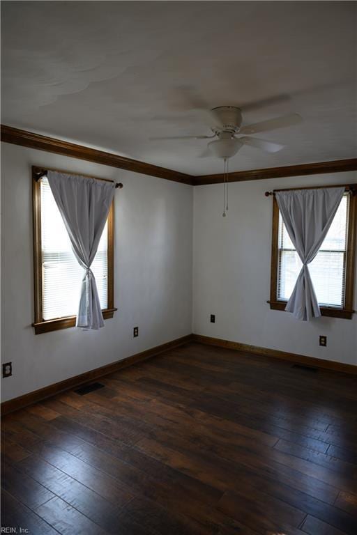 spare room featuring crown molding, plenty of natural light, ceiling fan, and dark hardwood / wood-style flooring