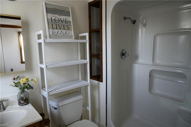 bathroom featuring toilet, walk in shower, and vanity