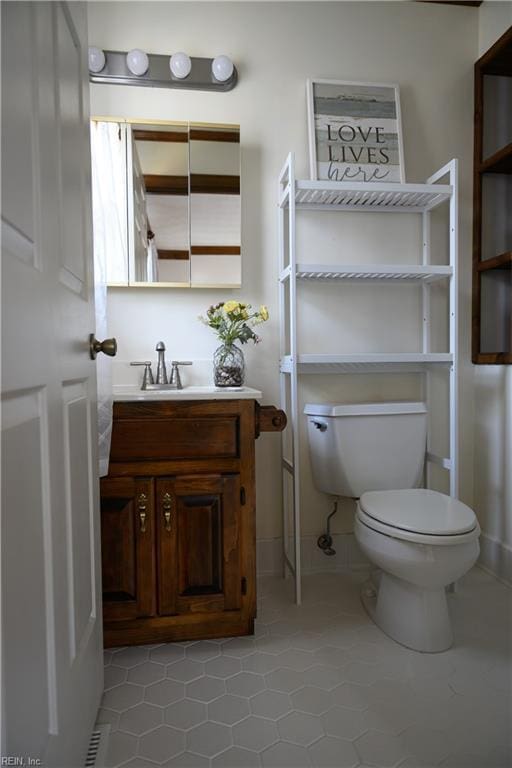 bathroom featuring toilet, vanity, and tile patterned flooring