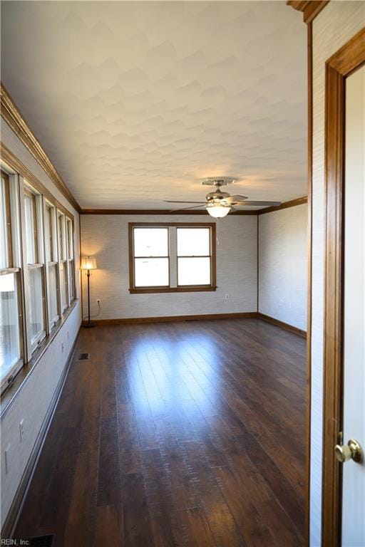 spare room featuring ceiling fan, crown molding, plenty of natural light, and dark hardwood / wood-style flooring